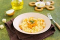 Vegetarian pumpkin risotto in a beige ceramic plate on a green concrete background. Italian food. Pumpkin recipes