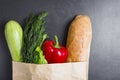 Vegetarian purchases at grocery store. Vegetables in paper bag on black background. Healthy food concept. Pack with vegetables Royalty Free Stock Photo