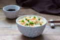 Vegetarian rice dish with vegetables and green peas on a wooden background