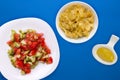 Vegetarian salad with cucumbers, tomatoes and green onions. Vegan salad on a white plate on a colored background.healthy