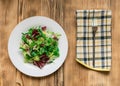 Vegetarian salad of fresh vegetables on a white plate on a wooden background Royalty Free Stock Photo