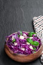 Vegetarian salad with red cabbage and apple in wooden bowl on black stone background Royalty Free Stock Photo