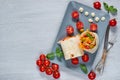 Vegetarian sandwich or lavash with fresh vegetables, sauce on the gray plate decotated with cherry tomatoes, basil leaves