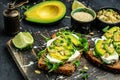 Vegetarian sandwiches. avocado toasts with rye bread on a dark background, Delicious breakfast or snack, Clean eating, dieting,