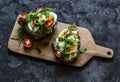 Vegetarian sandwiches with grain bread, avocado, boiled egg, micro-greens, cherry tomatoes and homemade mayonnaise on a cutting Royalty Free Stock Photo