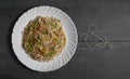 Vegetarian Schezwan Noodles or Vegetable Hakka Noodles or Chow Mein in white plate at wooden background. Schezwan Noodles is indo-