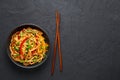 Vegetarian Schezwan Noodles or Vegetable Hakka Noodles or Chow Mein in black bowl at dark background. Indo-chinese cuisine hot Royalty Free Stock Photo