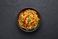 Vegetarian Schezwan Noodles or Vegetable Hakka Noodles or Chow Mein in black bowl at dark background. Schezwan Noodles is indo-