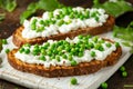 Vegetarian seeded sourdough bread open sandwich with cottage cheese and petit poit peas sprinkled with chilli flakes