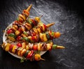 Vegetarian skewers with halloumi cheese and mixed vegetables on black background