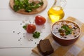 Vegetarian soup with beans, vegetables, cheese and olives stands on a yellow linen napkin. Nearby are tomatoes, rye bread, fresh Royalty Free Stock Photo