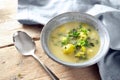 Vegetarian soup from vegetables like brussels sprout, leek and potato with parsley garnish in a blue bowl, spoon and napkin on a Royalty Free Stock Photo