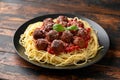 Vegetarian spaghetti with meat free, vegan meatballs in rich tomato sauce, grated cheese and basil leaves