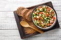 Vegetarian summer vegetable salad served with rye bread close-up in a bowl. horizontal top view