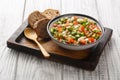 Vegetarian summer vegetable salad served with rye bread close-up in a bowl. horizontal