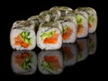 Vegetarian Sushi roll with vegetables: pepper, cucumber, avocado and salad isolated on black background with reflection Royalty Free Stock Photo