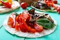 Vegetarian tacos with eggplant, cherry tomatoes, sweet peppers on a bright wooden background. Royalty Free Stock Photo