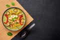 Vegetarian Thai Green Curry with tofu in black bowl at dark slate background. Thailand cuisine dish. Thai Food Royalty Free Stock Photo