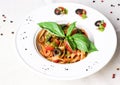 Vegetarian tomato pasta with pesto sauce, black olives and basil Royalty Free Stock Photo