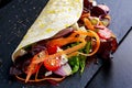 Vegetarian tortillas taco wrap with red onion, sweet cherry tomatoes, carrots, ruby chard, rocket and feta chees