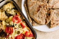 Vegetarian treats pizza with tomatoes, mozzarella and olives and naan with cheese and greens