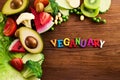 Vegetarian and vegan diet month in january called Veganuary. healthy raw vegetables and fruits on wooden background. Royalty Free Stock Photo