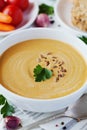 Vegetarian vegetable cream soup with eggplant and carrots in white bowl on wooden table Royalty Free Stock Photo