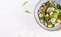 Vegetarian vegetable salad of radish, cucumbers, arugula and green onions. Royalty Free Stock Photo