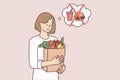 Vegetarian woman holding paper bag with fresh vegetables in hands refusing to buy fast food