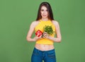 Vegetarian Young woman holding fresh raw vegetables salad pepper cucumber and parsley on green background. Healthy food Lifestyle Royalty Free Stock Photo