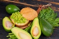 Veggie avocado sandwich with dill on the wooden board. Traditional healthy Mexican dish - diet green guacamole burger Royalty Free Stock Photo