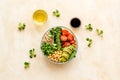 Veggie bowl. Vegetable salad with quinoa, avocado, tomato, spinach and chickpeas - on beige table. Top view