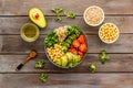 Veggie bowl. Vegetable salad with quinoa, avocado, tomato, spinach and chickpeas - on wooden table. Top view Royalty Free Stock Photo