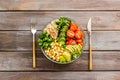 Veggie bowl. Vegetable salad with quinoa, avocado, tomato, spinach and chickpeas - on wooden table. Top view Royalty Free Stock Photo