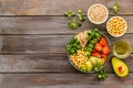 Veggie bowl. Vegetable salad with quinoa, avocado, tomato, spinach and chickpeas - on wooden table. Top view copy space Royalty Free Stock Photo