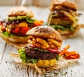 Veggie burgers, homemade vegan burger with fresh and grilled vegetables and aromatic curry sauce on a white rustic table.