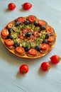 Veggie pizza with tomatoes, black olives on the gray concrete background. Vegetarian pizza with mushrooms and spices