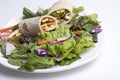 Veggie wrap on a fresh salad.