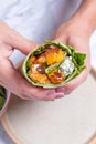 women hands holding a veggie wrap