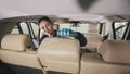 Vehicle cleaning - caucasian young woman is washing armchair of a luxury car with a brush Royalty Free Stock Photo