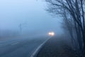 Vehicle coming out of a thick fog with switch on headlights