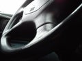 Vehicle interior. Dark steering wheel. The interior of the car cab. Dark upholstery. Vehicle keys in the contact slot. Round