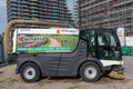 Vehicle for maintenance of green areas and road cleaning. Street cleaner vehicle at work in the city Royalty Free Stock Photo