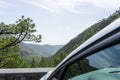 Vehicle parked in front of a green natural park on a view point. Panoramic of field and remote land