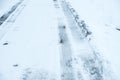 Vehicle tire tracks on road covered in snow and ice. Winter driving conditions Royalty Free Stock Photo