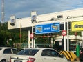 Vehicles entering highway toll canopy in Malaysia.