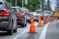 Vehicles are lined up in heavy traffic with bright orange cones marking an ongoing road construction area. The setting is a Royalty Free Stock Photo