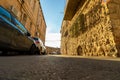 Vehicles are parked near crowded houses in a narrow alley in the famous neighborhood of Nachlaot