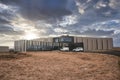 Vehicles parked outside luxurious resort amidst landscape against cloudy sky