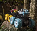 Monster car toys standing on stone and grass.